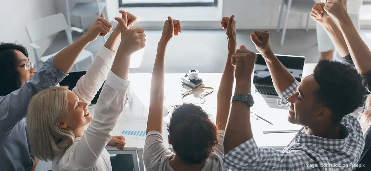 Team members give a thumbs up in the office